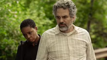 Tom (Mark Ruffalo) y Aleah (Thuso Mbedu) miran algo con curiosidad con árboles detrás de ellos en la temporada 1 de Task.