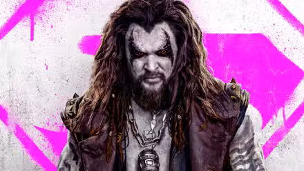 Lobo de Jason Momoa se para frente a un logo rosa de Supergirl