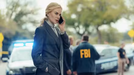 Nicole Kidman habla por teléfono con agentes del FBI al fondo en la temporada 3 de Lioness
