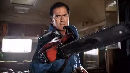 Ash sostiene su motosierra hacia la cámara en Ash vs. the Evil Dead