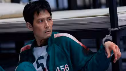 Lee Jung-jae como el jugador 456 esposado a una cama en el episodio 10 de la temporada 3 de Squid Game.