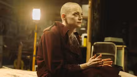 Una calva Emma Stone mira enojada a alguien en Bugonia