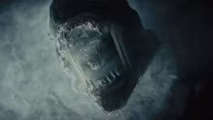 Un xenomorfo rugiendo a través del humo en Alien: Romulus.