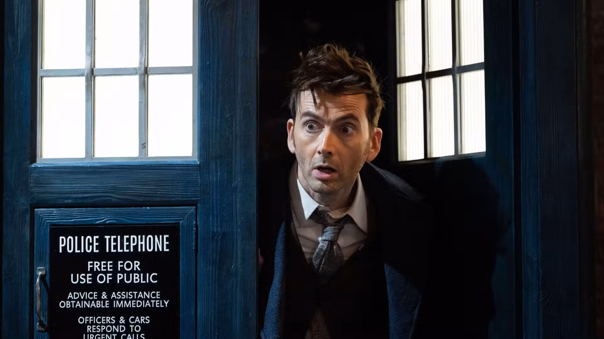 David Tennant como el Decimocuarto Doctor asomándose desde la TARDIS en Doctor Who