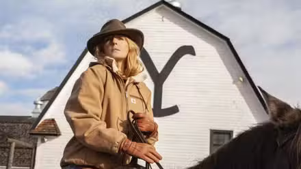 Kelly Reilly como Beth Dutton montando a caballo frente al rancho de Yellowstone en Yellowstone