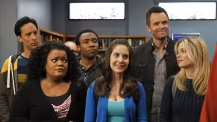 Annie sonríe mientras Britta y Shirley la miran con escepticismo, Troy, Abed y Jeff detrás de ellos.