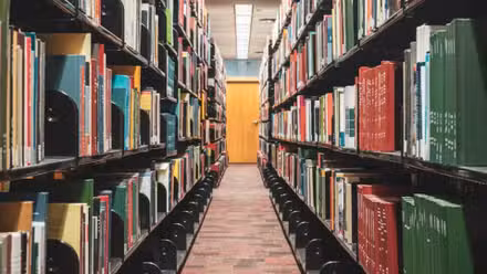  Un pasillo de biblioteca con libros a cada lado.