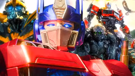 Transformers One, Optimus Prime (primer plano) y Autobots de acción real en el fondo.