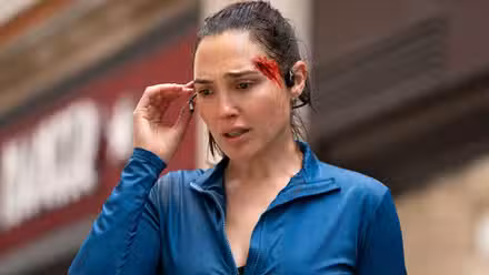 Maia de Gal Gadot parece preocupada mientras se lleva los auriculares a la oreja en The Runner
