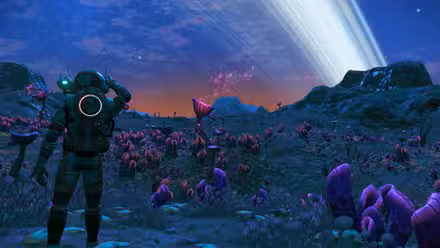 Un personaje jugador en No Man's Sky mirando los anillos del planeta sobre una cresta rocosa al atardecer.