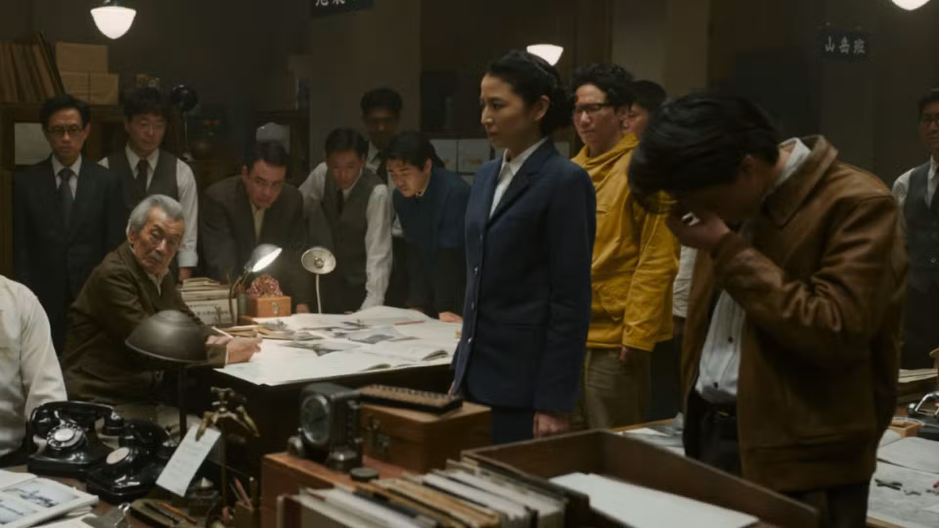 Un grupo de personas juntas intentando establecer un plan en Godzilla Minus Zero