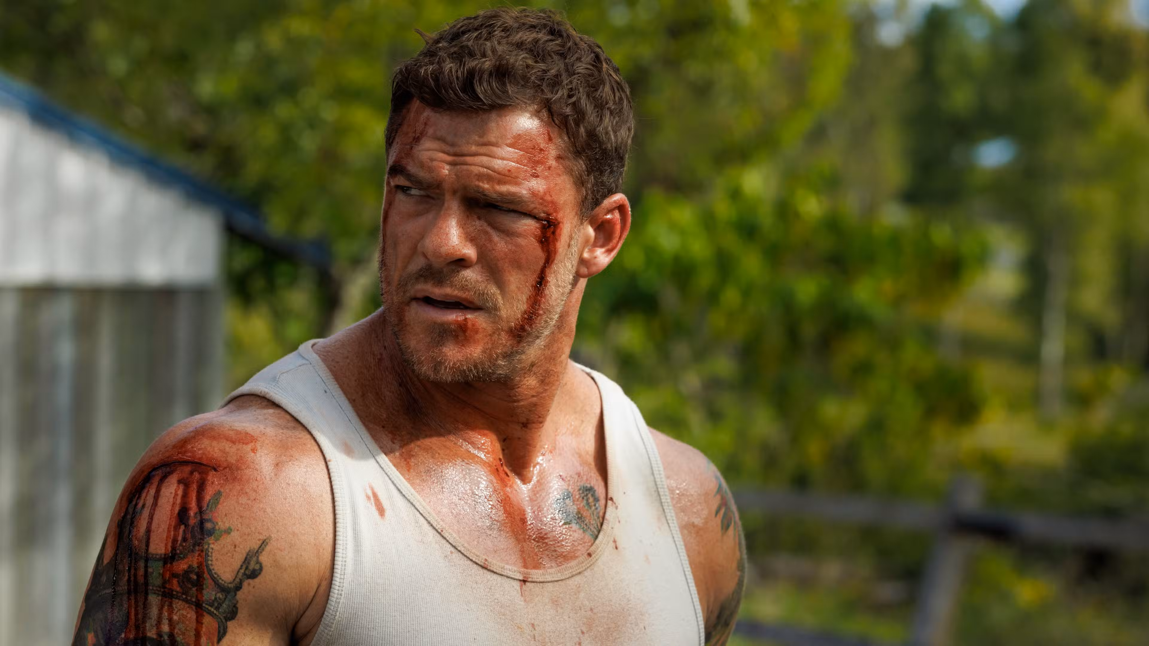 Un Alan Ritchson ensangrentado mira por encima del hombro en Runner
