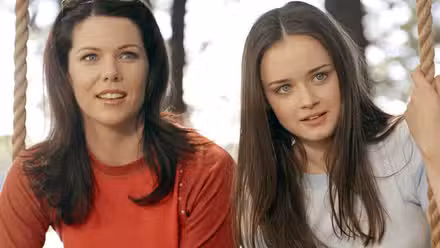 Lorelai (Lauren Graham) y Rory (Alexis Bledel) sentados en un columpio en Gilmore Girls