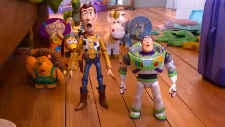 Woody y Buzz lucen sorprendidos frente a los otros juguetes en Toy Story 5