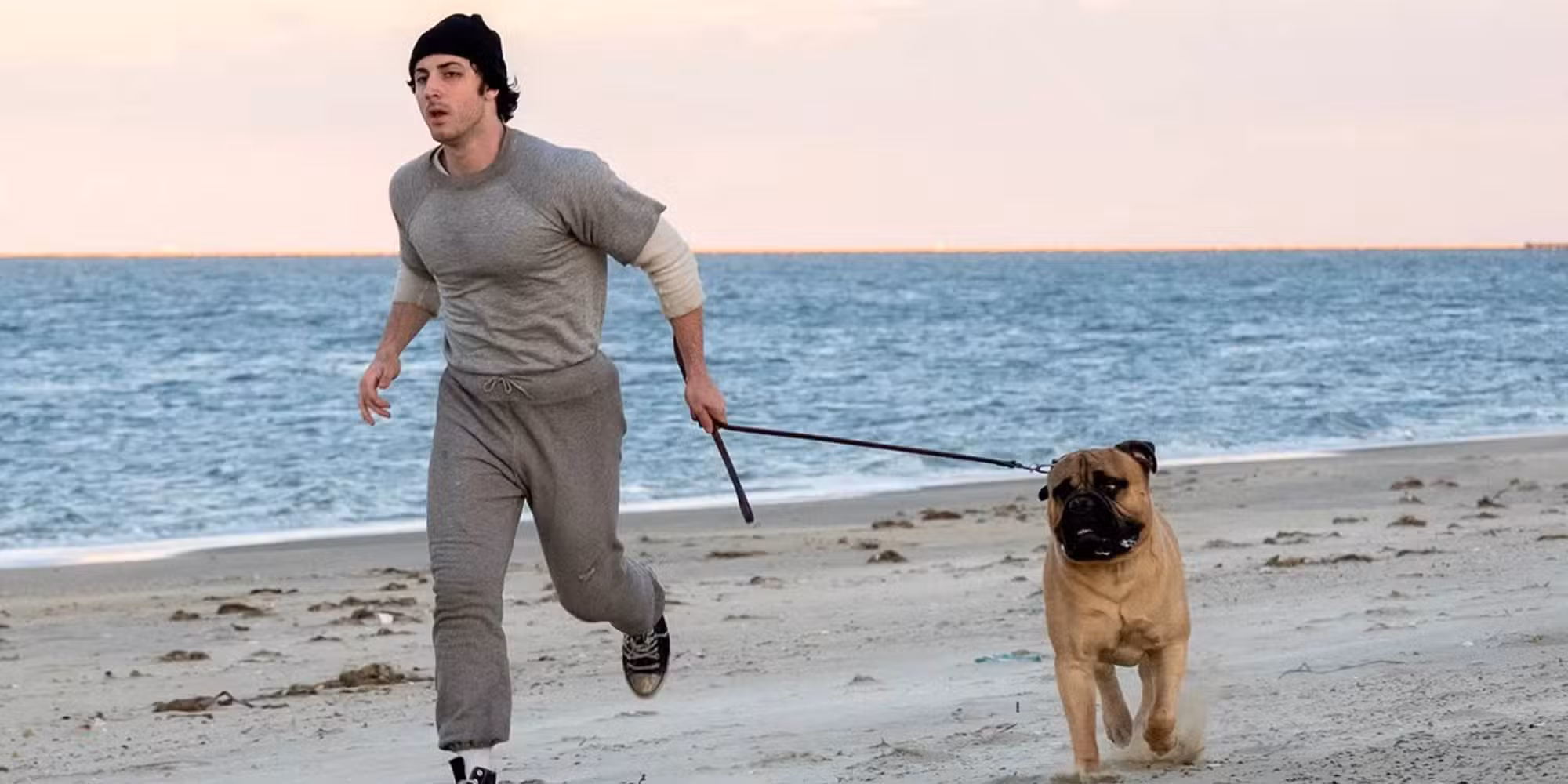 Sylvester Stallone y un perro corriendo en la playa en I Play Rocky