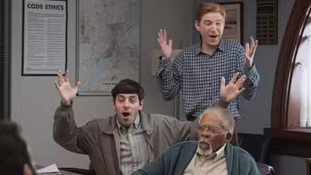 Ned de Domnhall Gleeson y Adam de Alex Edelman celebrando algo en la temporada 1 de The Paper