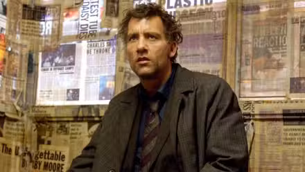 Clive Owen como Theo en una habitación con ventanas cubiertas de periódicos en Children of Men