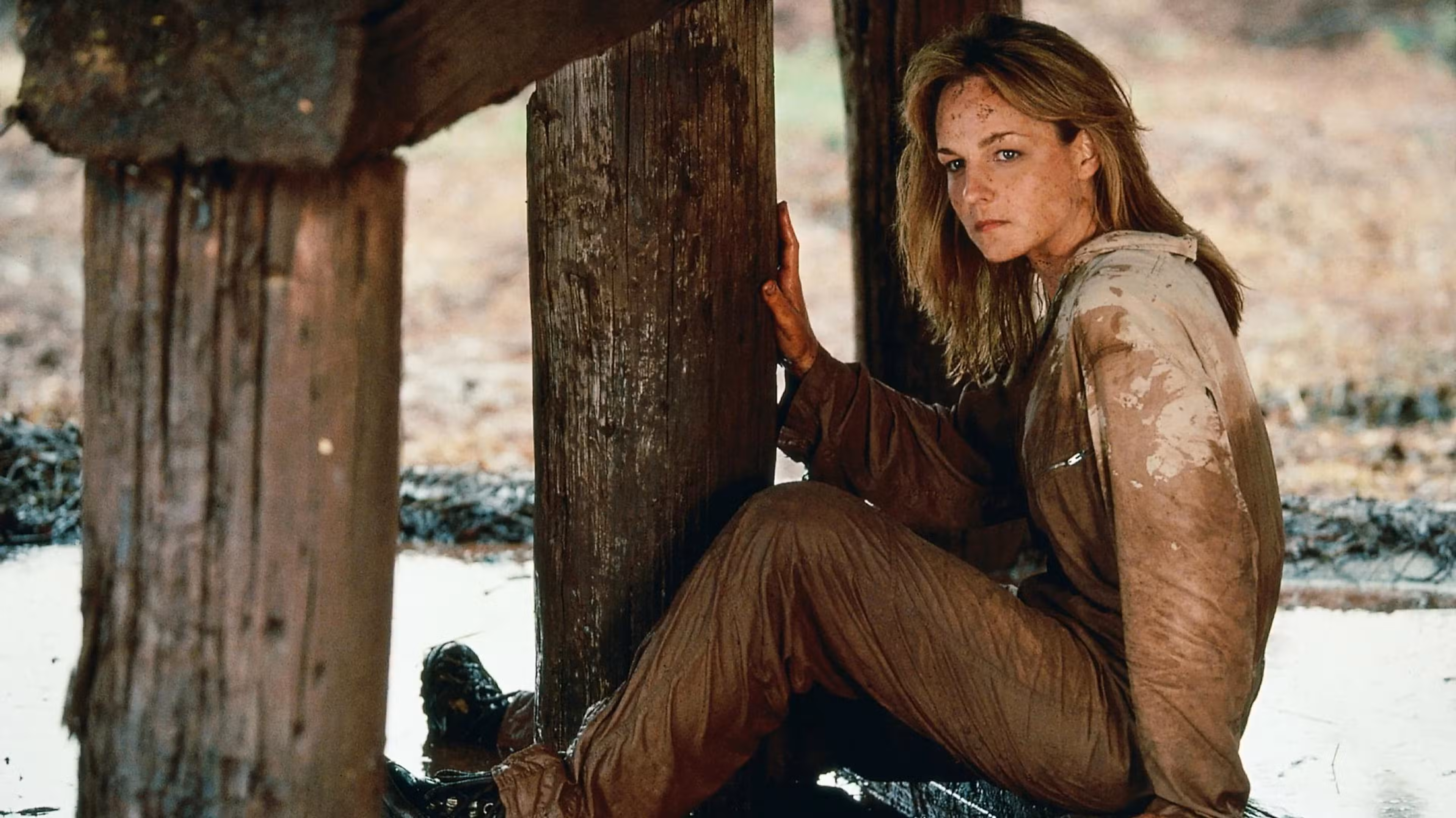 Jo de Helen Hunt mira intensamente mientras está sentada en una estructura destruida en Twister