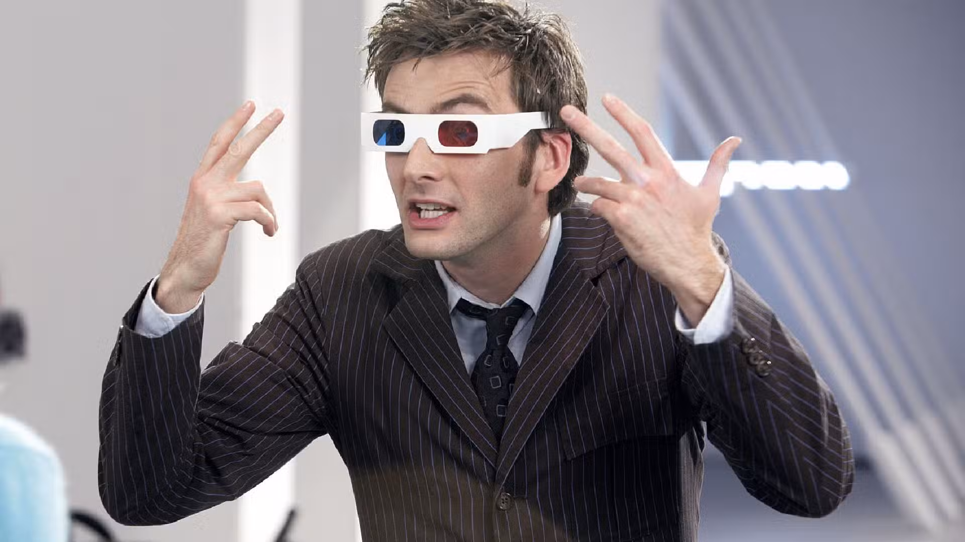 David Tennant como el Décimo Doctor explicando algo mientras usa gafas 3D en Doctor Who.