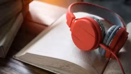 Auriculares apilados en un libro abierto