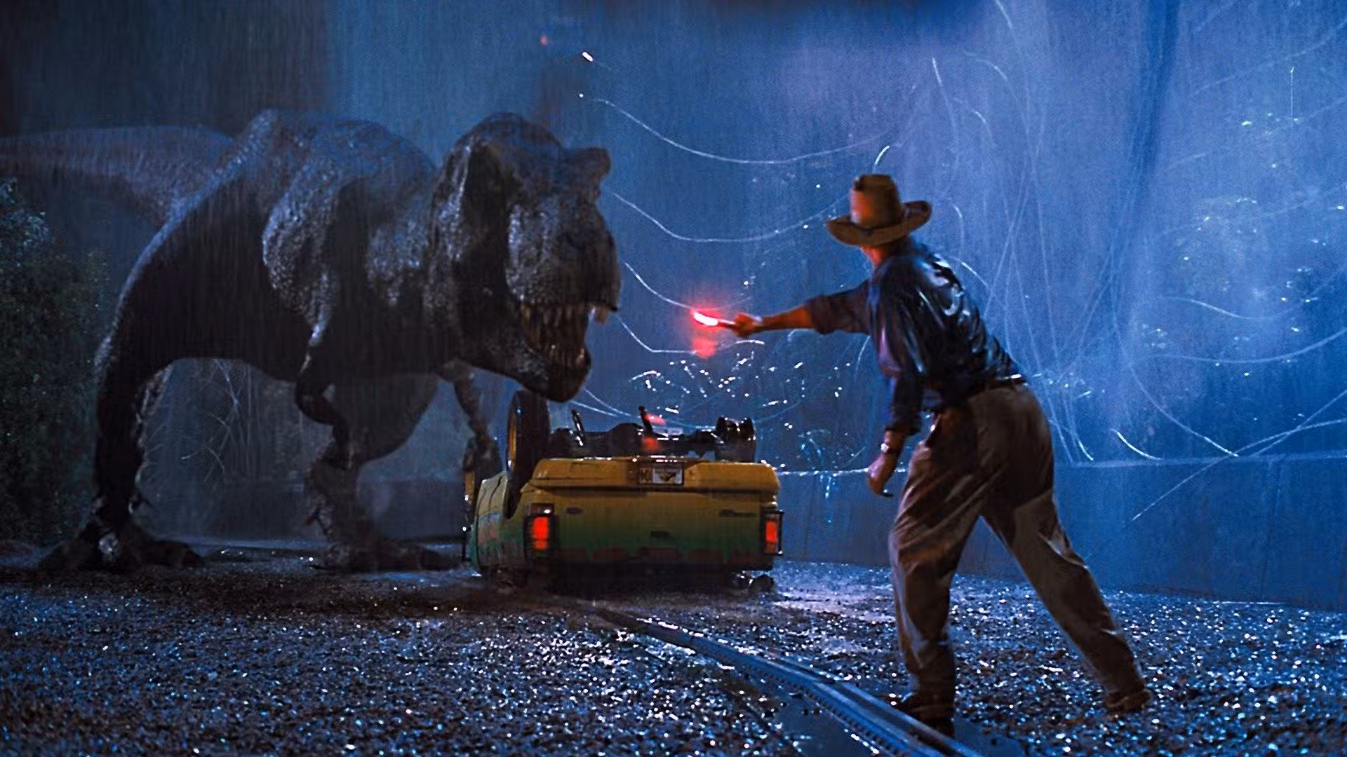 El T-Rex de Jurassic Park ataca el coche mientras Alan Grant (Sam Neill) sostiene una bengala