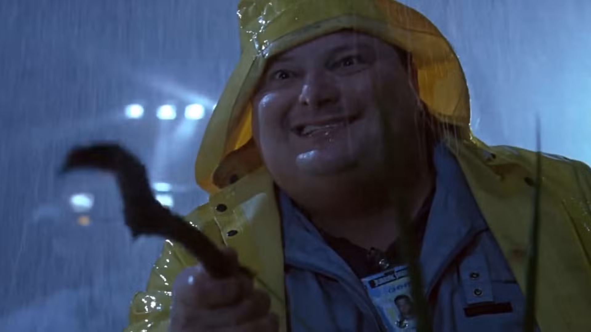 Dennis Nedry sosteniendo un palo intentando jugar con un dilofosaurio en Jurassic Park