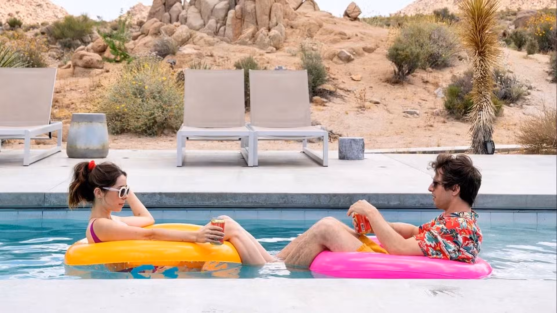 Un hombre y una mujer flotan en cámaras de aire de una piscina en Palm Springs.