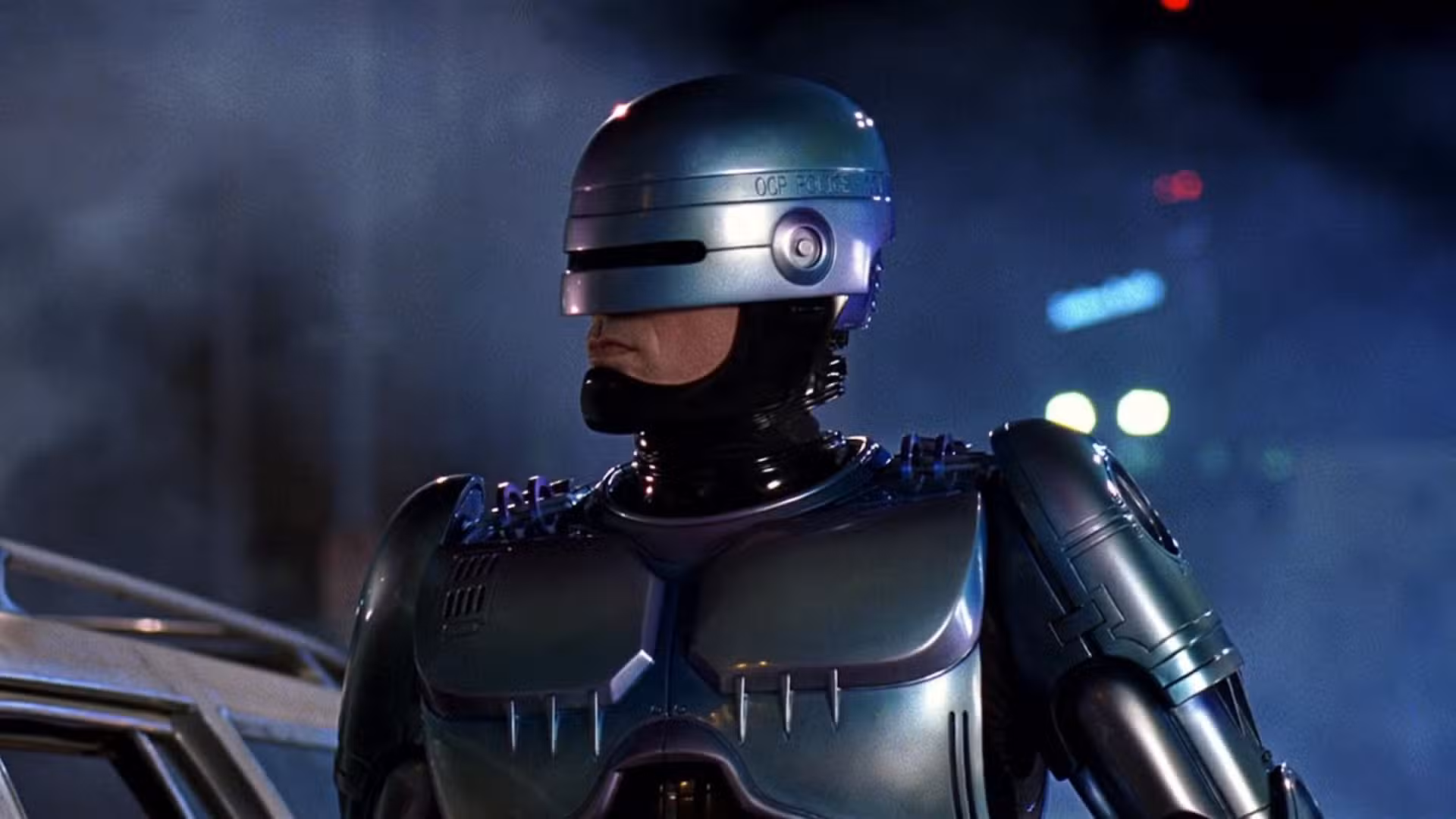 RoboCop parado afuera por la noche junto a un auto