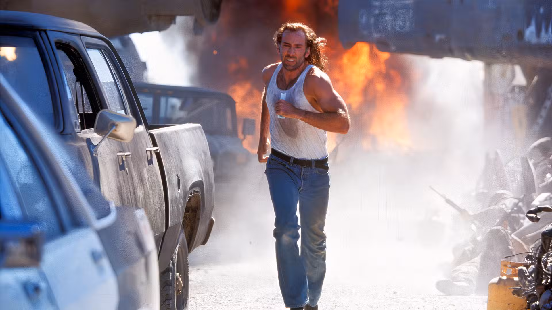 Nicolas Cage como Poe huyendo de una explosión en Con Air