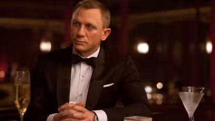 Daniel Craig como James Bond con esmoquin y sentado en un bar en Skyfall