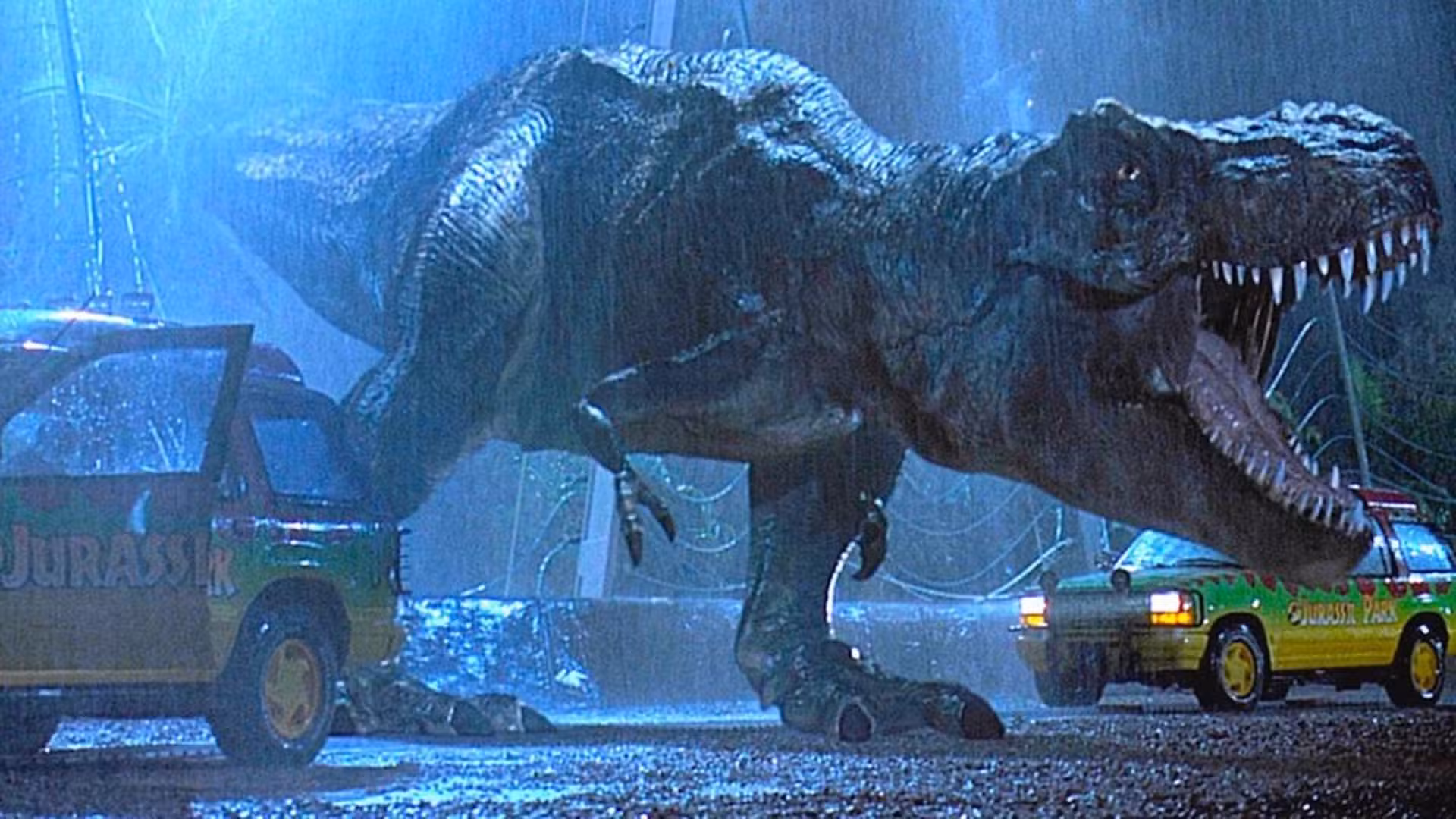 Tiranosaurio escapando de su recinto entre dos autos en Jurassic Park