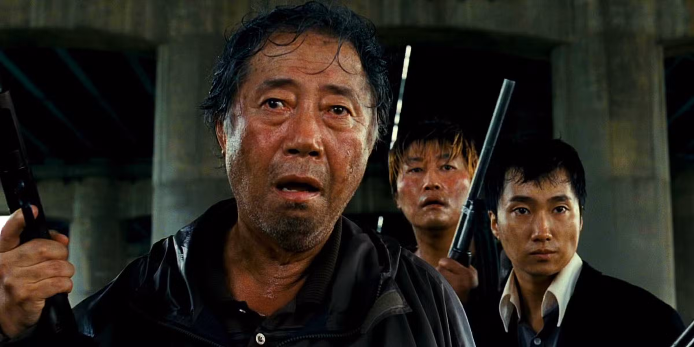 Imagen de The Host 2006 Bong Joon-ho que muestra a un hombre sorprendido, parado frente a otros dos hombres con armas de fuego.