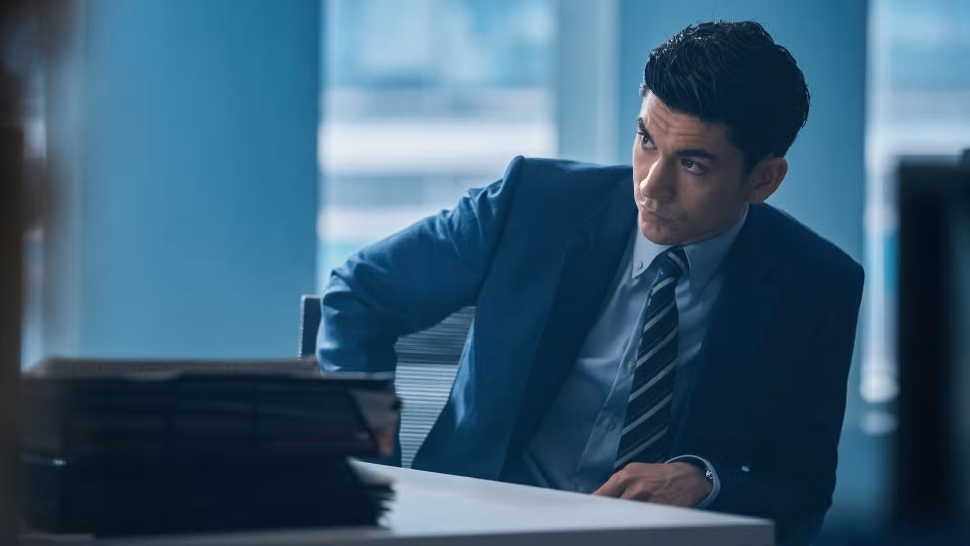 Johnny se sienta como un escritorio mirando nerviosamente hacia un lado en War de HBO