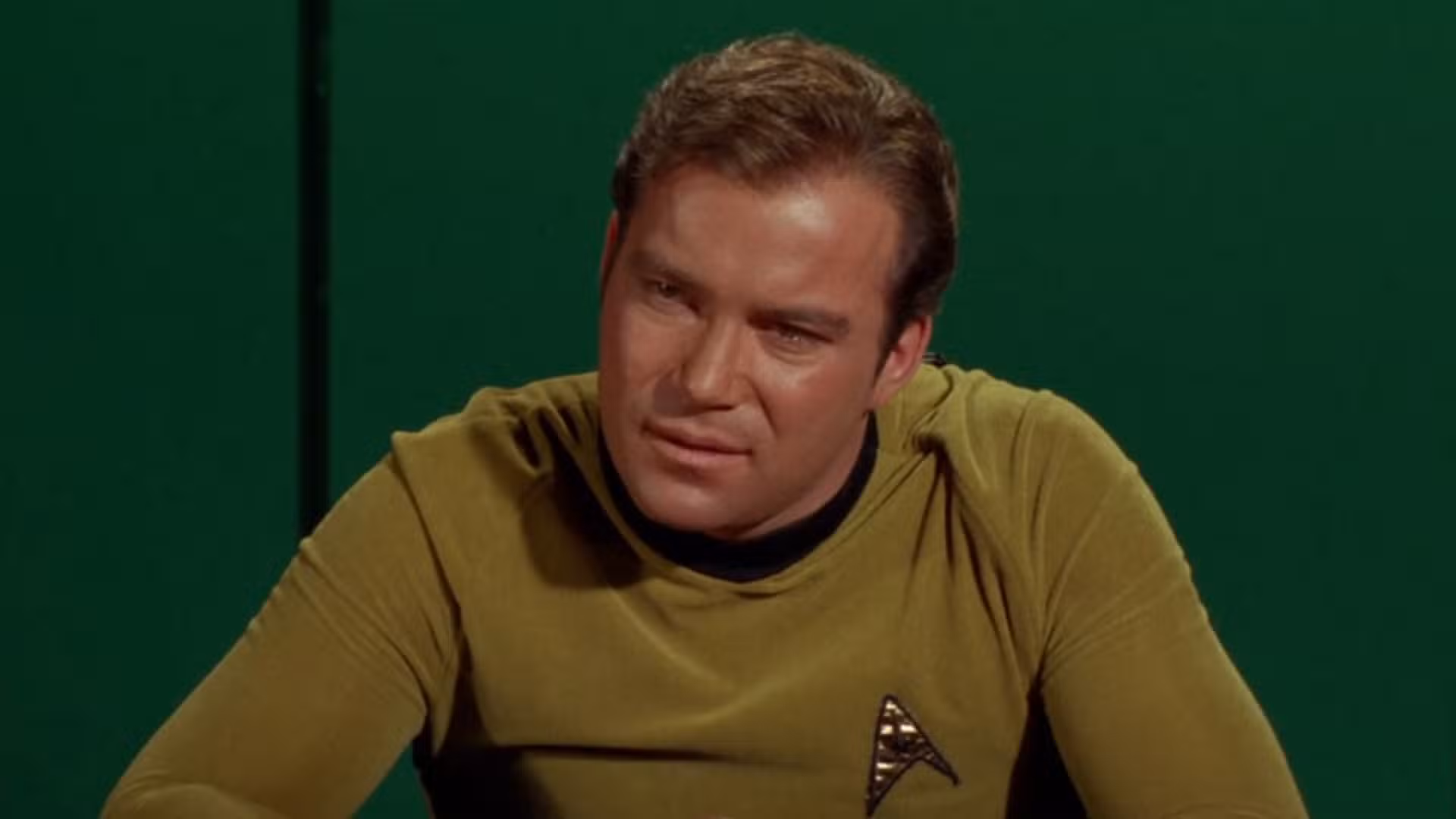 Kirk pronuncia un apasionado discurso en una sala de reuniones de Enterprise