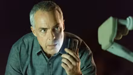 Harry Bosch sosteniendo una grabadora de voz en Bosch