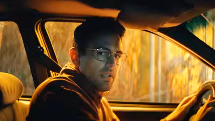 Theo James parece preocupado al volante de un coche en The Monkey