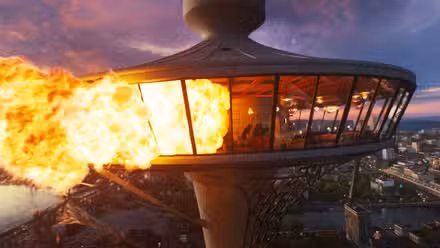 El restaurante Skyview con llamas saliendo de sus ventanas izquierdas en Final Destination Bloodlines