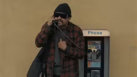 Leonardo DiCaprio como Bob en un teléfono público en Una batalla tras otra