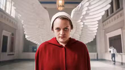 Offred de The Handmaid's Tale viste su túnica roja con alas blancas detrás de ella.