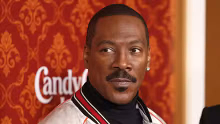 Eddie Murphy luce serio mientras está en la alfombra roja de Candy Cane Lane.